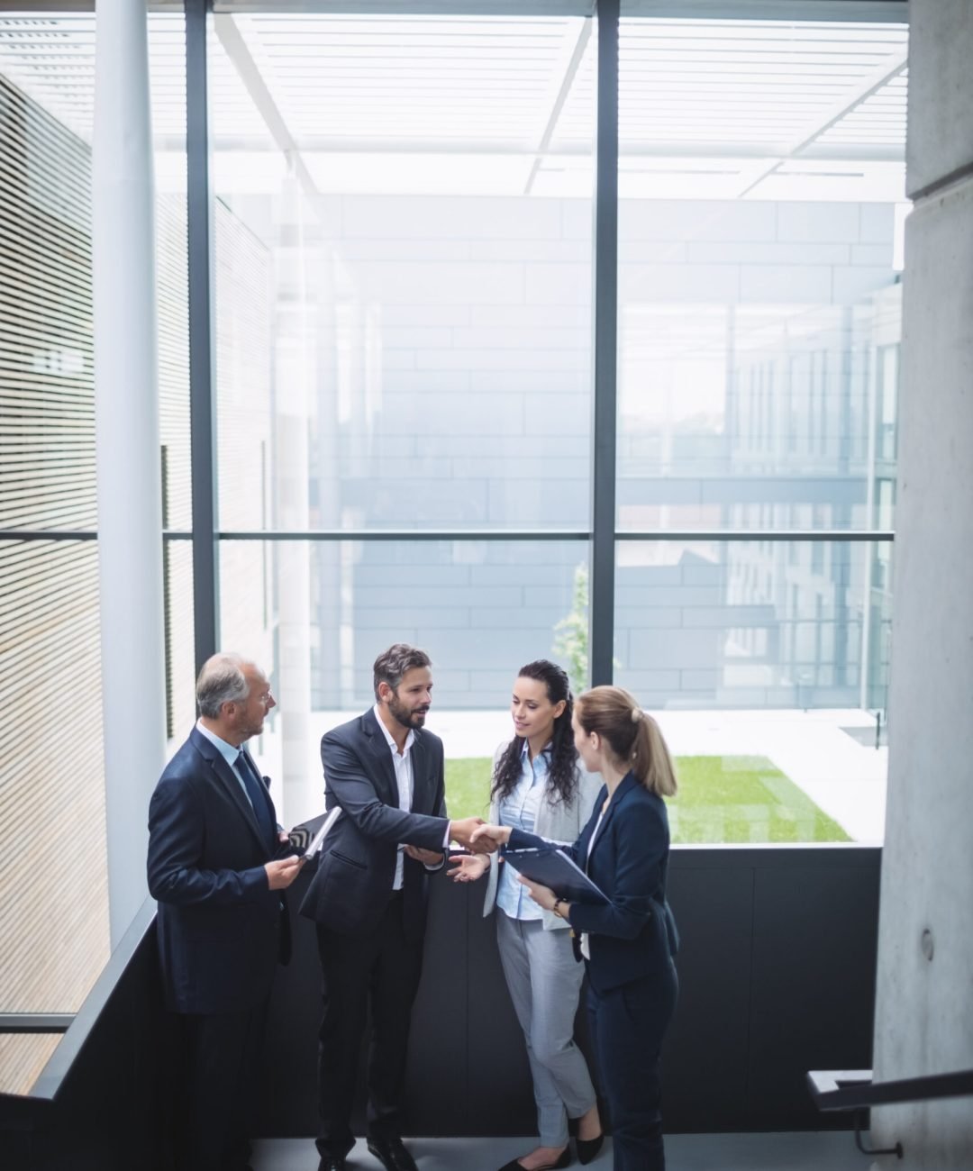 Group of businesspeople having a discussion near staircase in office