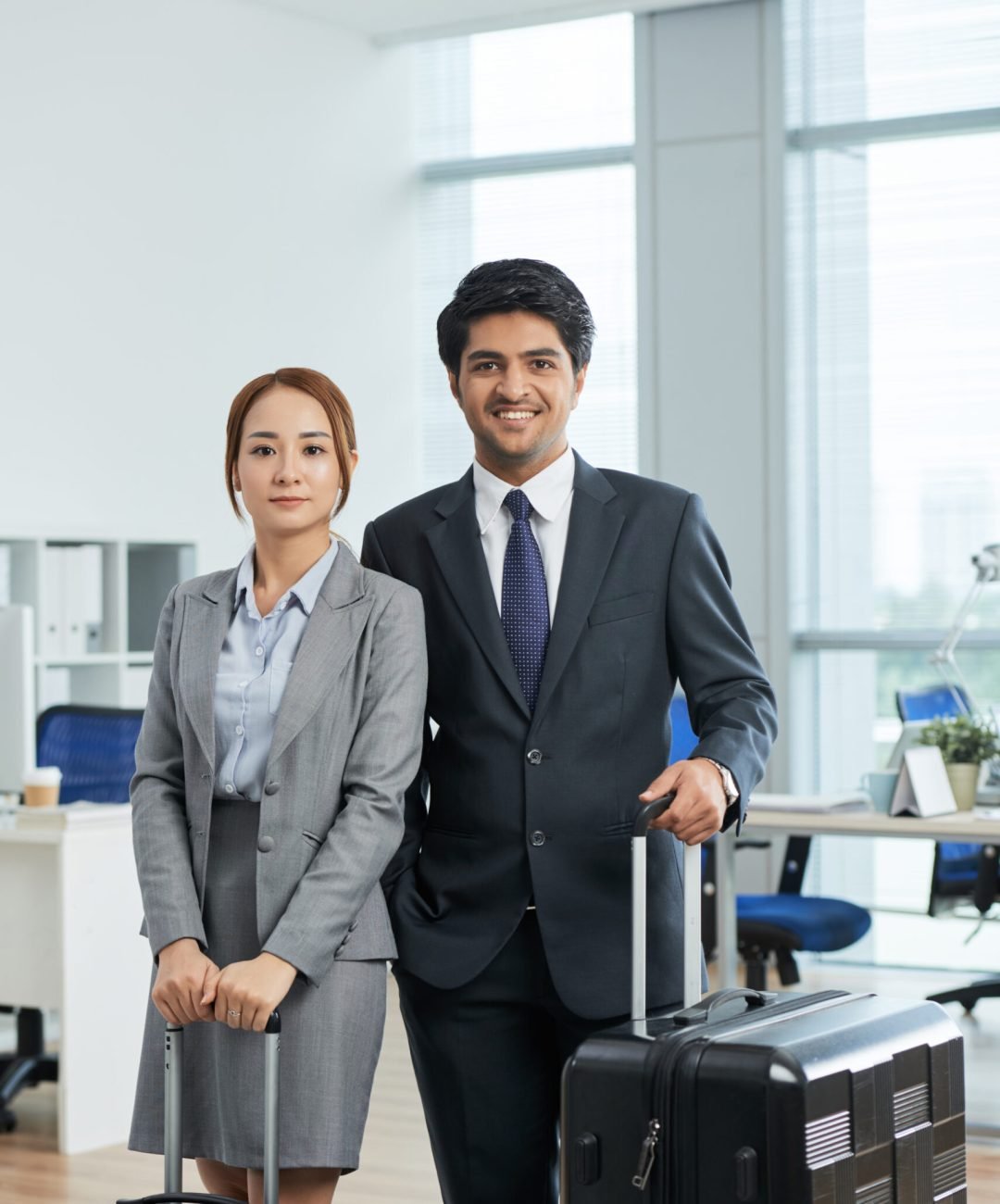 knee-up-shot-man-woman-suits-posing-office-with-suitcases-before-business-trip